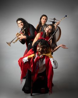 La trompeta y el clarinete detrás de la figurina, de rojo.